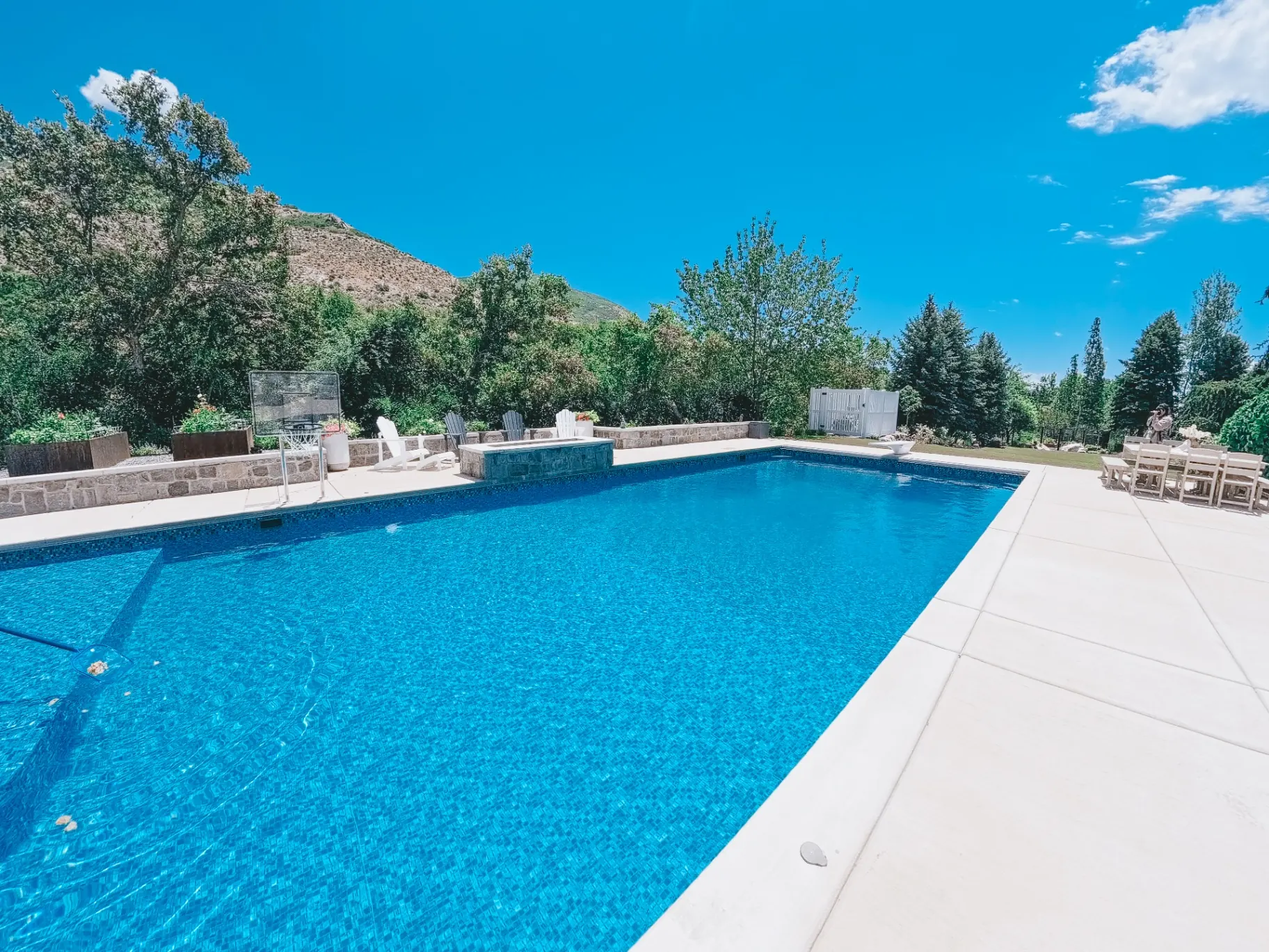 Large custom vinyl inground swimming pool with mosaic tile, in-pool basketball hoop and Wasatch mountain views in Ogden, Utah by Barr Pool Builders